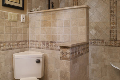 Mediterranean bathroom in Philadelphia with a two-piece toilet, beige tile and stone tile.