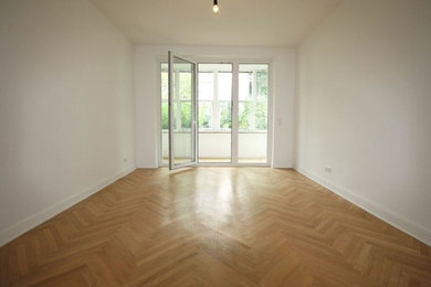 Large traditional formal enclosed living room in Frankfurt with white walls, light hardwood floors, no fireplace, no tv and beige floor.