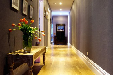 Example of a small classic medium tone wood floor and brown floor hallway design in New York with purple walls