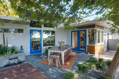 This is an example of a mid-sized mid-century modern back porch design in Phoenix with decking.