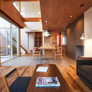 Modern inredning av ett mellanstort allrum med öppen planlösning, med bruna väggar, mellanmörkt trägolv, en fristående TV och brunt golv