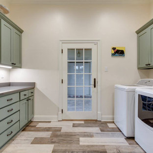 他の地域のコンテンポラリースタイルのおしゃれな洗濯室 (シェーカースタイル扉のキャビネット、緑のキャビネット、ベージュの壁、合板フローリング、左右配置の洗濯機・乾燥機、マルチカラーの床、グレーのキッチンカウンター) の写真