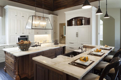 Kitchen - transitional kitchen idea in New York with paneled appliances, two islands and white countertops