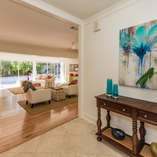 Design ideas for a mid-sized eclectic foyer in Tampa with white walls, travertine floors, a single front door, a dark wood front door and beige floor.