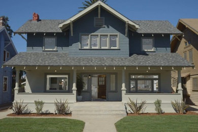 This is an example of an arts and crafts two-storey blue exterior in Los Angeles with wood siding.