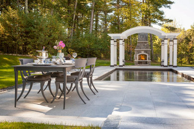 Diseño de jardín grande en verano en patio trasero con jardín francés, chimenea, exposición parcial al sol, adoquines de piedra natural y con metal