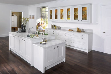 Inspiration for a mid-sized contemporary galley eat-in kitchen in Sydney with an undermount sink, shaker cabinets, white cabinets, quartz benchtops, stainless steel appliances, dark hardwood floors, with island and white benchtop.