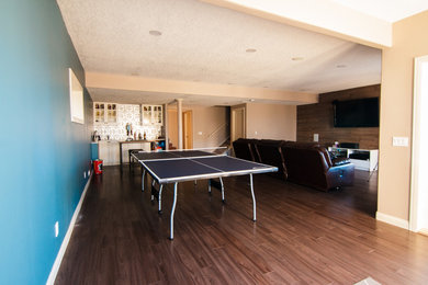 Example of a mid-sized classic walk-out laminate floor and brown floor basement design in Calgary with blue walls