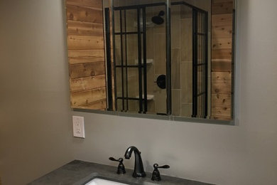 Small 3/4 brown tile and ceramic tile ceramic tile and green floor corner shower photo in Seattle with furniture-like cabinets, distressed cabinets, a one-piece toilet, white walls, an undermount sink, concrete countertops, a hinged shower door and gray countertops