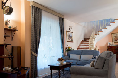 Foto di un soggiorno classico con pareti rosa, pavimento in gres porcellanato, porta TV ad angolo e pavimento beige