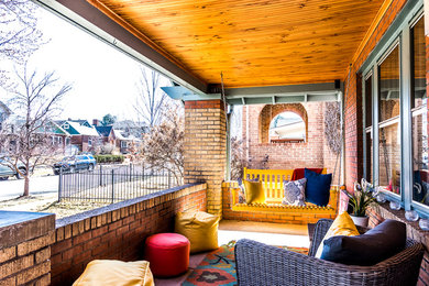 Small arts and crafts concrete front porch idea in Denver with a roof extension