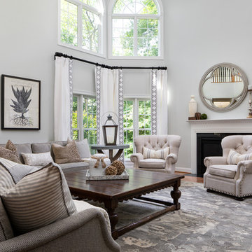 Neutral Two Story Family Room with Tufted Wing Chairs