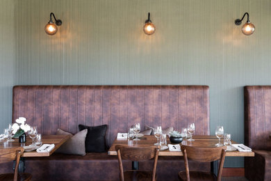 Idée de décoration pour une salle à manger ouverte sur le salon urbaine avec un mur vert.