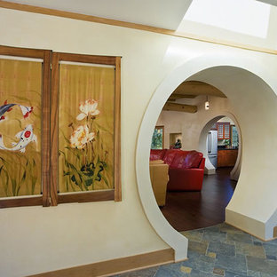 Asiatisk inredning av en mellanstor hall, med vita väggar, skiffergolv och flerfärgat golv