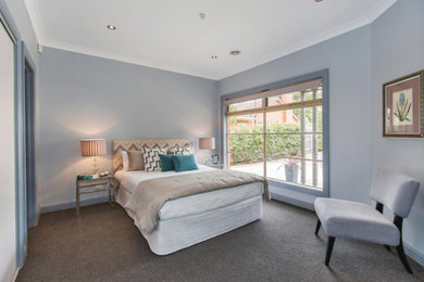 Inspiration for a mid-sized transitional guest bedroom in Melbourne with grey walls and carpet.