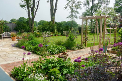 This is an example of a mid-sized traditional backyard garden for summer in Hampshire with gravel.