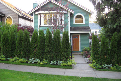 Photo of a mid-sized traditional drought-tolerant and partial sun backyard stone landscaping in Vancouver.