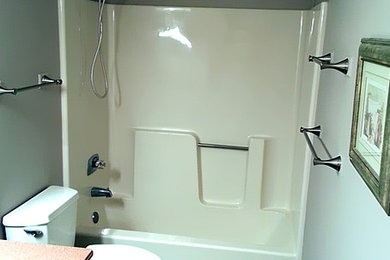 Master gray tile and ceramic tile ceramic tile tub/shower combo photo in New York with white cabinets, beige walls and wood countertops