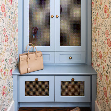 Mudroom hall area with wallpapered walls and custom blue cabinets