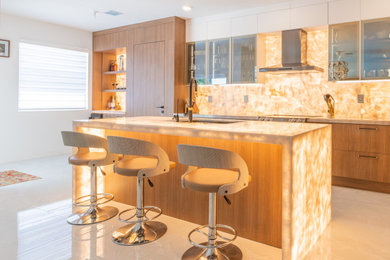 Eat-in kitchen - large modern l-shaped porcelain tile and gray floor eat-in kitchen idea in Miami with a drop-in sink, flat-panel cabinets, medium tone wood cabinets, quartzite countertops, multicolored backsplash, marble backsplash, black appliances, an island and multicolored countertops