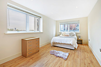 Imagen de dormitorio principal grande con paredes blancas, suelo vinílico y suelo beige