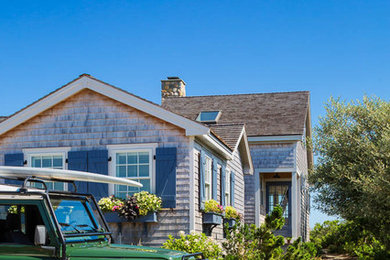 Photo of a small beach style two-storey exterior in Boston with wood siding and a shed roof.