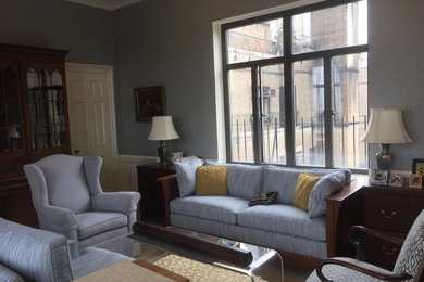 Living room - mid-sized traditional enclosed dark wood floor and brown floor living room idea in New York with gray walls