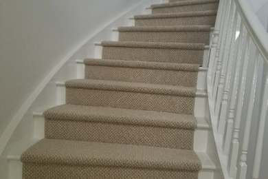 Carpeted curved staircase in Miami with carpet risers.