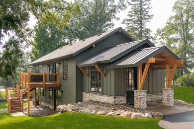 Mid-sized rustic green two-story wood and board and batten exterior home idea in Minneapolis with a mixed material roof and a black roof