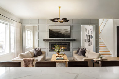 Inspiration for a mid-sized transitional open concept light wood floor living room remodel in Nashville with a two-sided fireplace, a stone fireplace and a wall-mounted tv