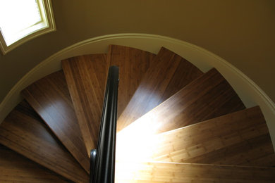 This is an example of a contemporary wood spiral staircase in Seattle with wood risers.