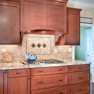 Idées déco pour une grande arrière-cuisine classique en U avec un évier encastré, un placard avec porte à panneau encastré, des portes de placard en bois brun, un plan de travail en granite, une crédence multicolore, une crédence en carrelage métro, un électroménager en acier inoxydable, un sol en bois brun et un îlot central.