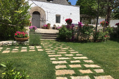 Immagine di un ingresso o corridoio rustico con pareti bianche, pavimento in pietra calcarea, una porta grigia e pavimento beige