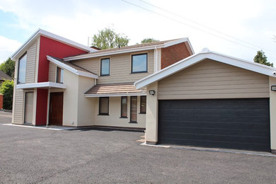 Multi-coloured contemporary detached house in Other with a pitched roof and a tiled roof.