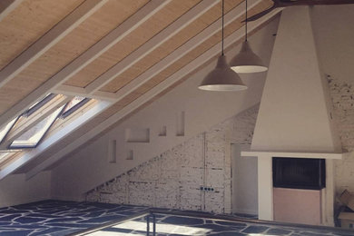 Imagen de biblioteca en casa abierta grande con paredes blancas, suelo de pizarra, chimenea de doble cara, marco de chimenea de yeso, suelo negro, machihembrado y ladrillo