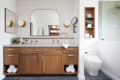 Large 1960s master gray tile gray floor and single-sink shower bench photo in Los Angeles with shaker cabinets, medium tone wood cabinets, a one-piece toilet, white walls, an undermount sink, quartz countertops, a hinged shower door, gray countertops and a built-in vanity