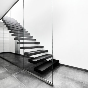Kragarmtreppe in matt schwarz mit Weißglas