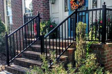 This is an example of a mid-sized traditional brick front porch design in Other.