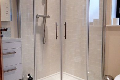 Kleines Modernes Badezimmer En Suite mit Eckdusche, weißen Fliesen, Porzellanfliesen, weißer Wandfarbe, Porzellan-Bodenfliesen, buntem Boden und Schiebetür-Duschabtrennung in Belfast