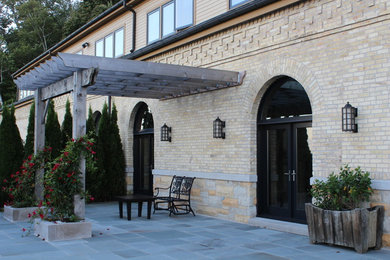 Large mountain style beige brick exterior home photo in Chicago