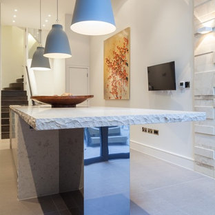 Large contemporary eat-in kitchen in London with an integrated sink, dark wood cabinets, limestone benchtops, white splashback, glass sheet splashback, stainless steel appliances and with island.
