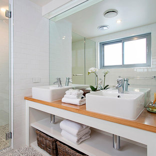 Kleines Tropisches Badezimmer En Suite mit offenen Schränken, weißen Schränken, Duschnische, Toilette mit Aufsatzspülkasten, beigefarbenen Fliesen, weißer Wandfarbe, Keramikboden, Aufsatzwaschbecken und Waschtisch aus Holz in Sunshine Coast