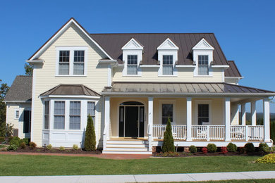 Example of a classic yellow two-story vinyl gable roof design in Other