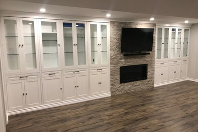 Example of a laminate floor and brown floor basement design in Toronto