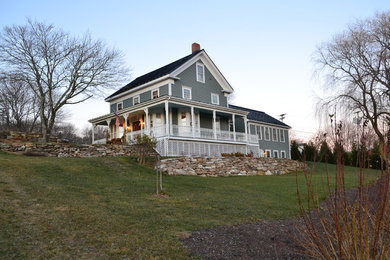 Example of a large classic blue three-story wood exterior home design in Boston with a shingle roof