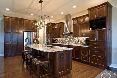 Kitchen - large contemporary l-shaped dark wood floor and brown floor kitchen idea in Other with an undermount sink, recessed-panel cabinets, dark wood cabinets, granite countertops, multicolored backsplash, glass tile backsplash, stainless steel appliances and an island