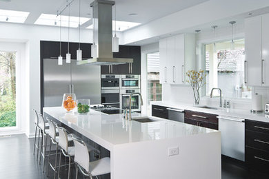 Open concept kitchen - contemporary u-shaped dark wood floor open concept kitchen idea in Indianapolis with an undermount sink, flat-panel cabinets, dark wood cabinets, quartz countertops, white backsplash, porcelain backsplash and stainless steel appliances