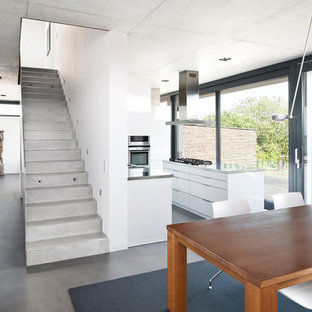 ニュルンベルクの中サイズのコンテンポラリースタイルのLDKの画像 (白い壁、コンクリートの床)