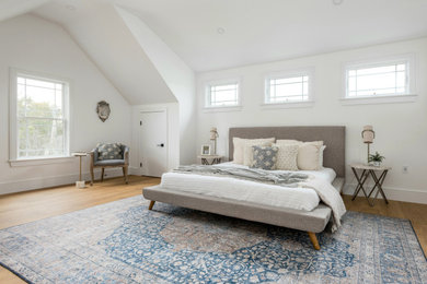 Example of a transitional master medium tone wood floor bedroom design with white walls
