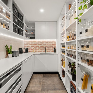 Moderne Küche mit Vorratsschrank, Unterbauwaschbecken, offenen Schränken, weißen Schränken, Küchenrückwand in Beige, braunem Boden, weißer Arbeitsplatte und Rückwand aus Backstein in Perth